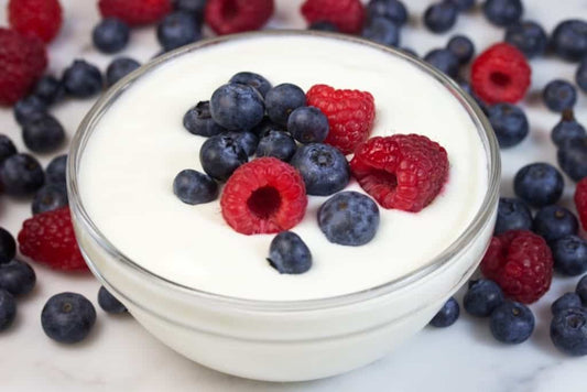 bowl of yogurt topped with fresh blueberries and raspberries for probiotics use