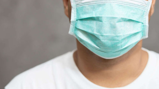 Close-up of person wearing a surgical mask to prevent bird flu infection
