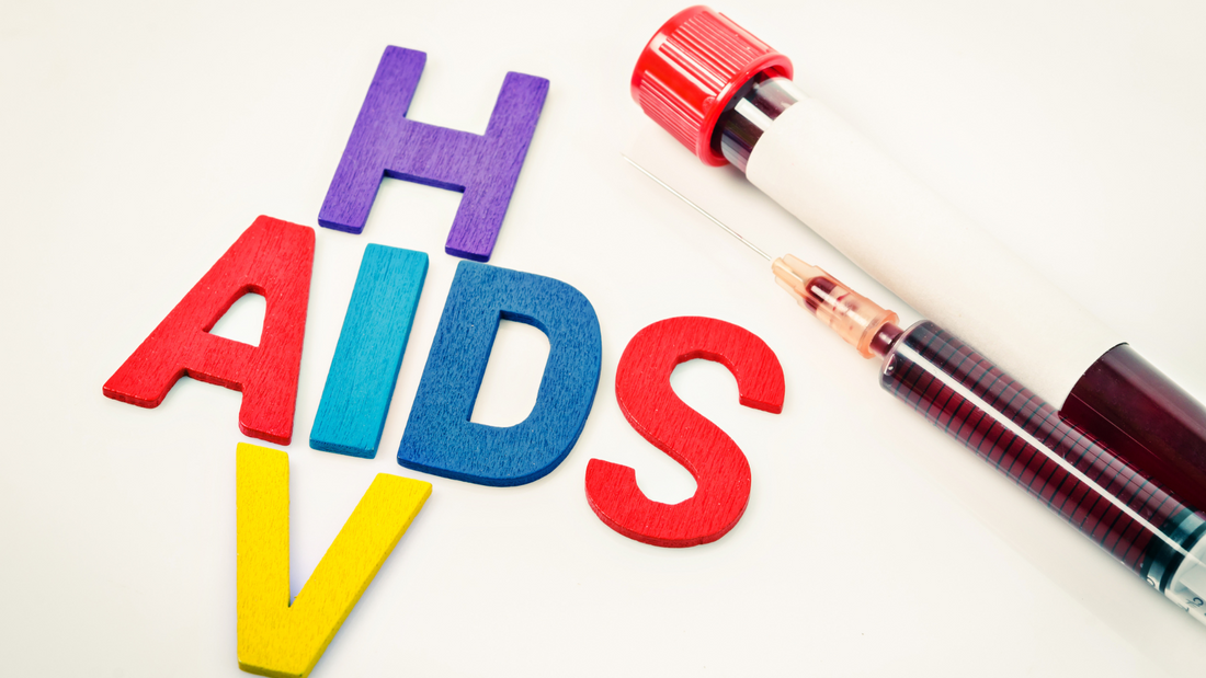 Colorful wooden letters spelling HIV AIDS next to a blood-filled syringe and test tube on white background