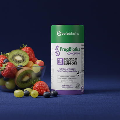 PregBiotics Conception probiotic supplement bottle with assorted fresh fruit on blue surface background