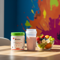 BioGain Probiotics Meal supplement container with a strawberry smoothie and fresh fruit bowl on a wooden table against colorful wall background